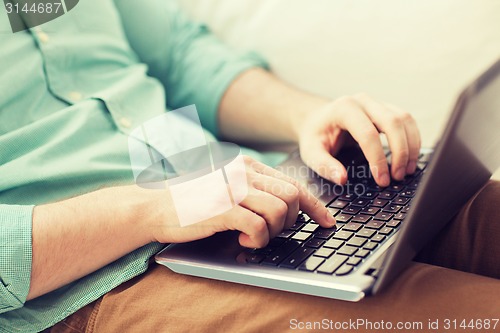 Image of close up of man working with laptop at home