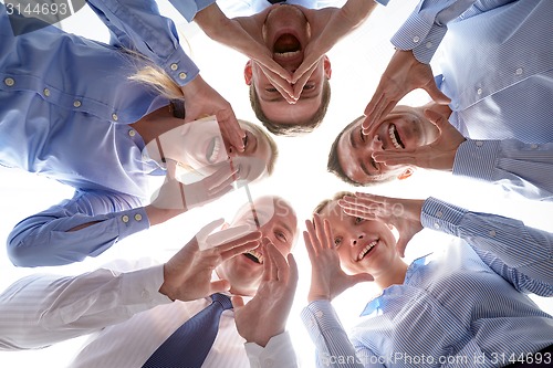 Image of smiling group of businesspeople standing in circle