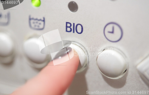 Image of close up of woman finger pressing washer button