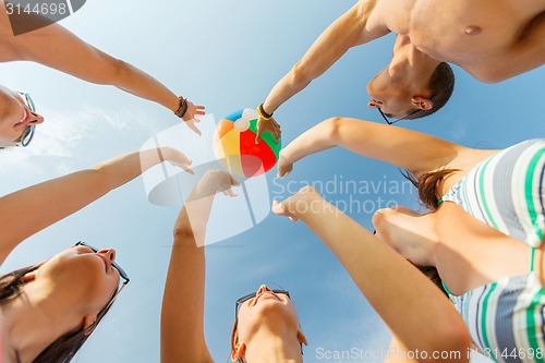 Image of smiling friends in circle on summer beach