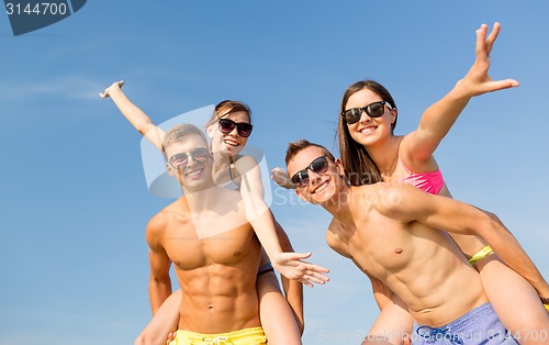 Image of smiling friends having fun on summer beach