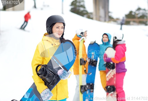 Image of happy friends in helmets with snowboards