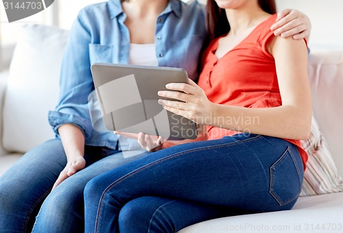 Image of close up of lesbian couple with tablet pc at home