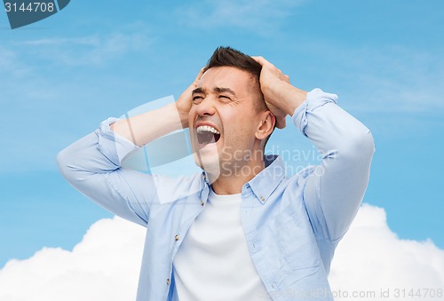 Image of unhappy man with closed eyes touching his forehead