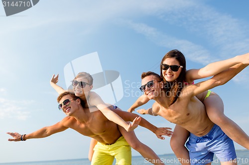 Image of smiling friends having fun on summer beach