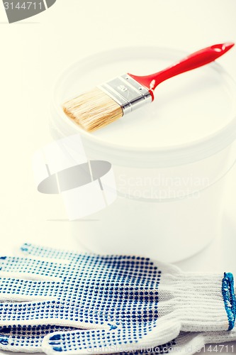Image of paintbrush, paint pot and gloves