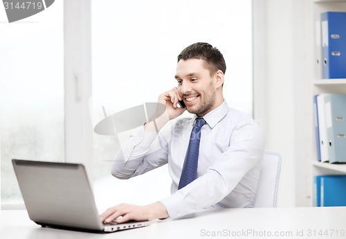 Image of businessman with laptop and smartphone at office