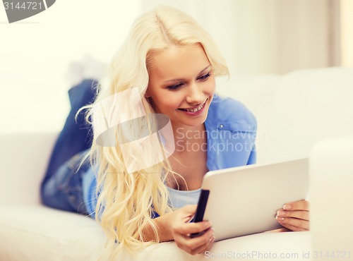 Image of smiling woman with tablet pc computer at home