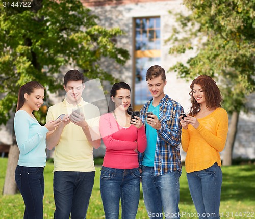 Image of group of smiling teenagers with smartphones