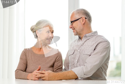Image of happy senior couple sitting on sofa at home