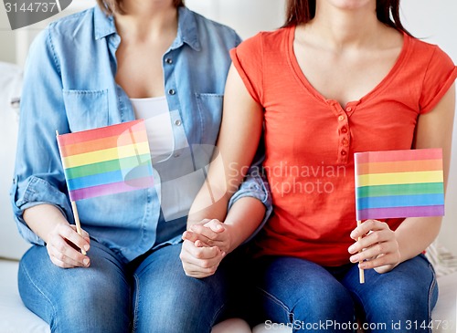 Image of close up of lesbian couple with rainbow flags