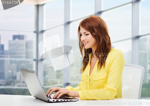 Image of smiling young woman with laptop computer