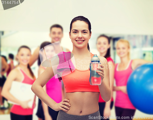 Image of sporty woman with towel and water bottle