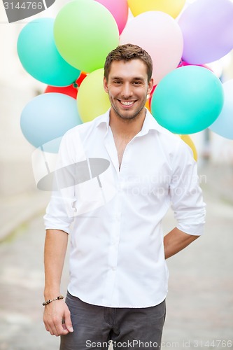 Image of man with colorful balloons in the city