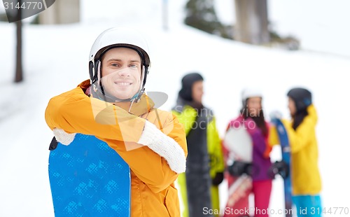 Image of happy friends in helmets with snowboards