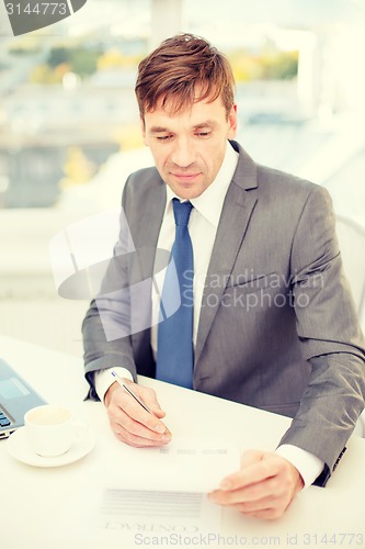 Image of businessman with laptop computer and documents