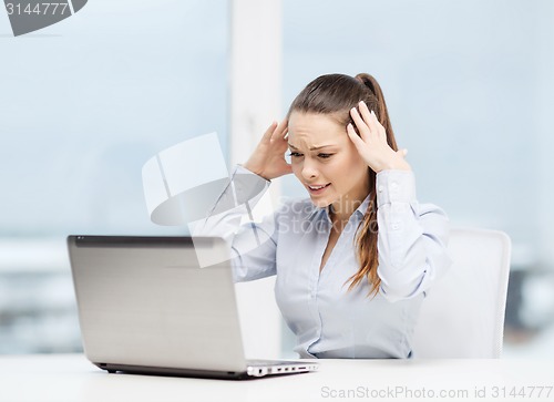 Image of stressed woman with laptop