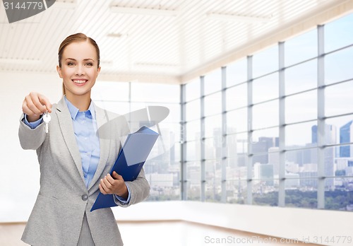 Image of smiling businesswoman with folder and keys