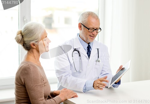 Image of smiling senior woman and doctor with tablet pc