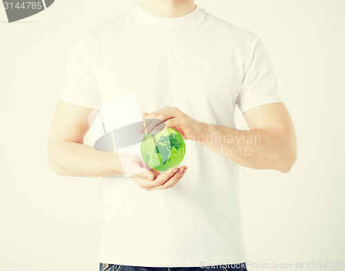 Image of man hands holding green sphere globe