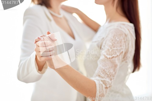 Image of close up of happy married lesbian couple dancing