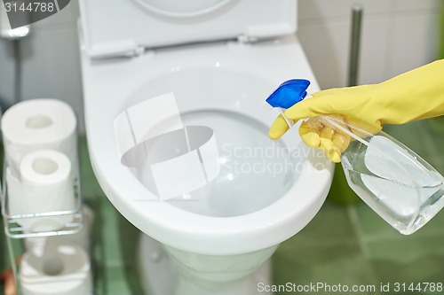 Image of close up of hand with detergent cleaning toilet