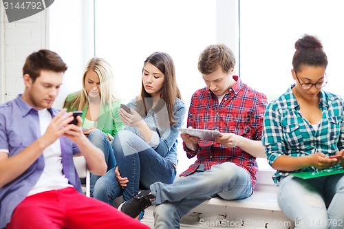 Image of students looking into devices at school