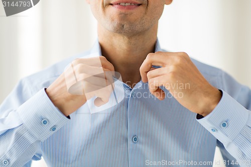 Image of close up of smiling man in shirt dressing 