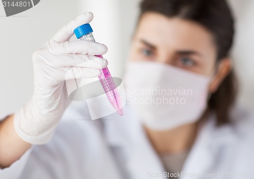 Image of close up of scientist with tube making test in lab