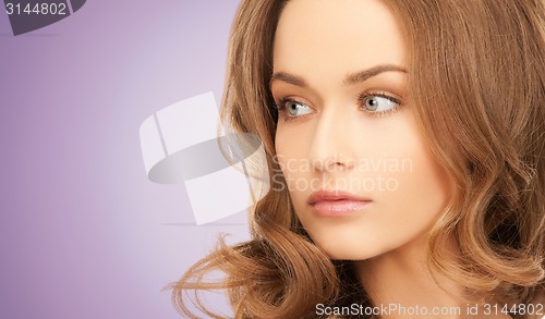 Image of beautiful young woman face over violet background