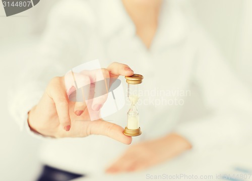 Image of woman hand with sandglass