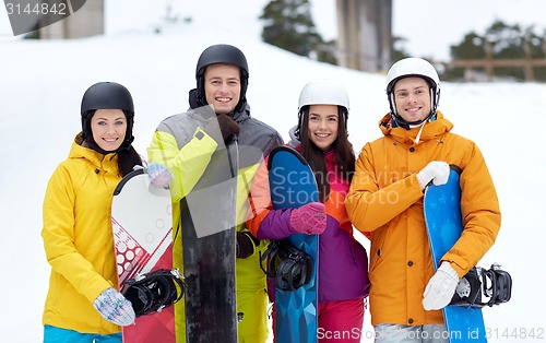 Image of happy friends in helmets with snowboards