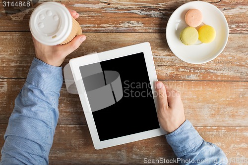Image of close up of male hands with tablet pc and coffee