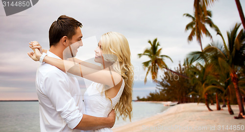 Image of happy couple hugging over beach background