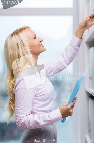 Image of smiling businesswoman or secretary in office