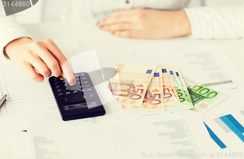 Image of woman hand with calculator and euro money