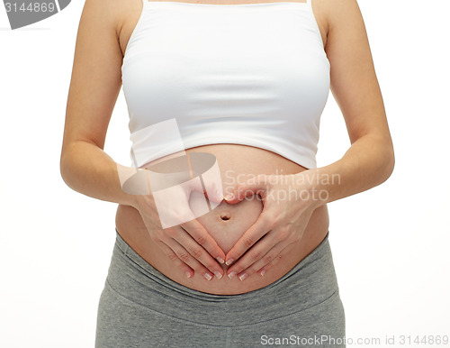 Image of close up of pregnant woman touching her bare tummy