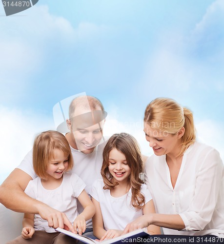 Image of happy family with book at home