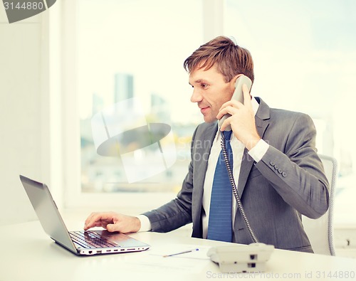 Image of businessman with laptop computer and phone