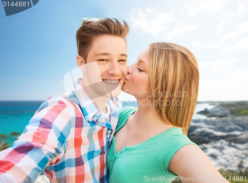 Image of happy couple taking selfie on summer beach