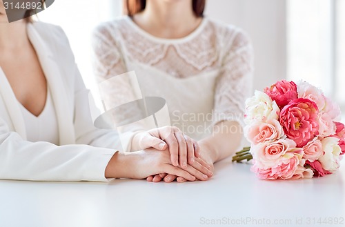 Image of close up of happy lesbian couple with flowers