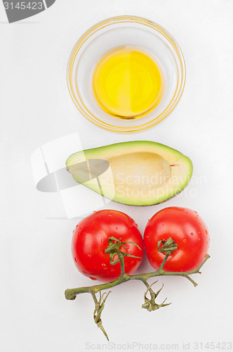 Image of Top view to the tomatoes, avocado and olive oil