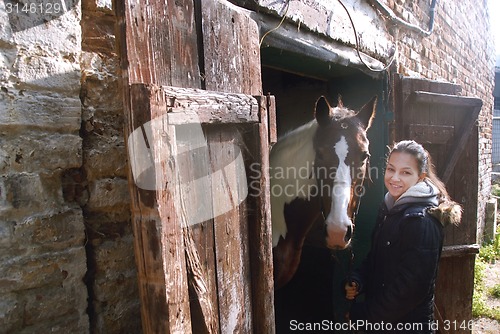 Image of Teenage girl with her beautiful horse friend