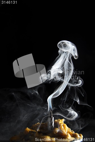 Image of White candle smoke at dark background