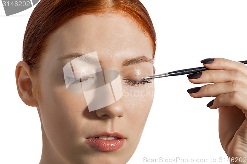 Image of Pretty Woman Applying Eye Shadow Makeup