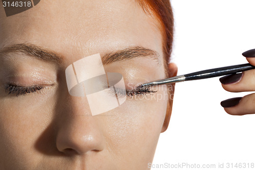 Image of Pretty Woman Applying Eye Shadow Makeup