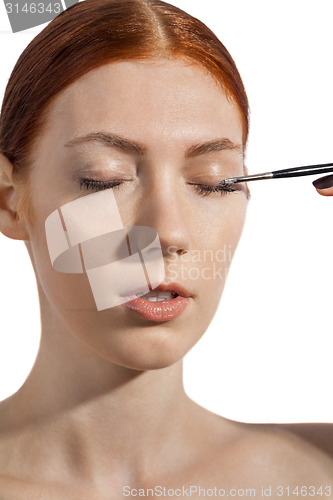 Image of Pretty Woman Applying Eye Shadow Makeup