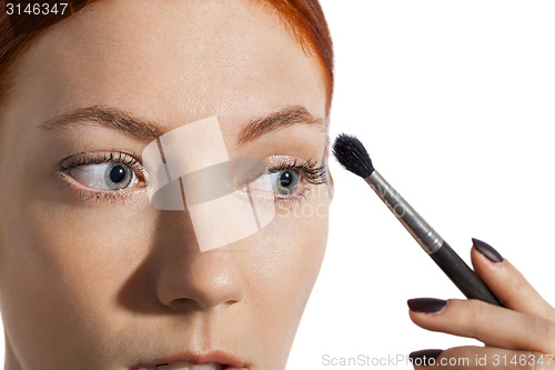Image of Pretty Woman Applying Eye Shadow Makeup