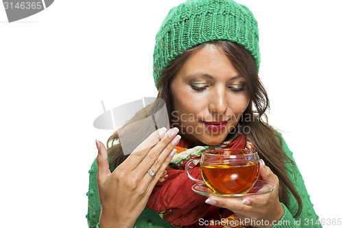 Image of Attractive woman warming up with a cup of hot tea