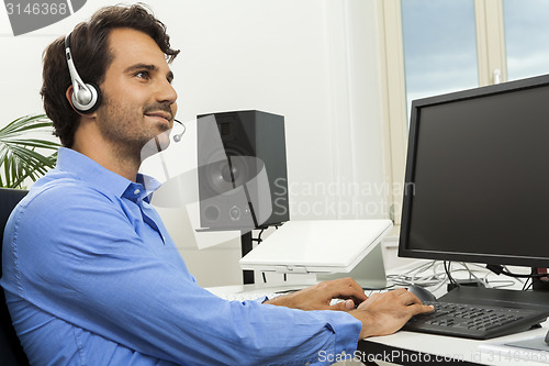 Image of Man wearing headset giving online chat and support